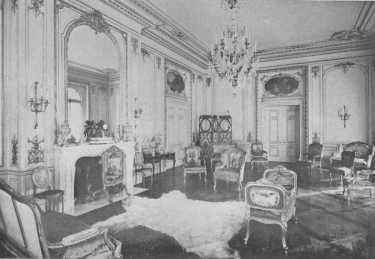 The mantel with its great glass reaching to the cornice,
the wall panels, paintings over the doors, and beautiful furniture, all
show the spirit of the best Louis XV period. The fur rug is an
anachronism and detracts from the effect of the room.