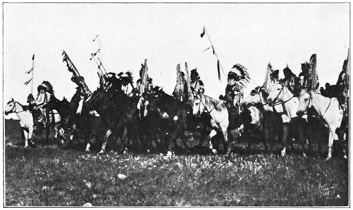 A LINE OF WARRIORS WITH WAR BONNETS